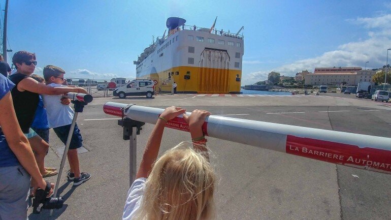 Fähre legt rückwärts im Hafen von olbia an und Kinder gucken zu