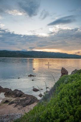 Kind auf einem SUP beim Sonnenuntergang