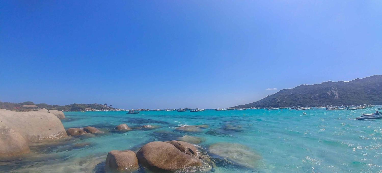 türkis Wasser mit Steinen im Wasser am Strand von Santa Giulia auf Korsika