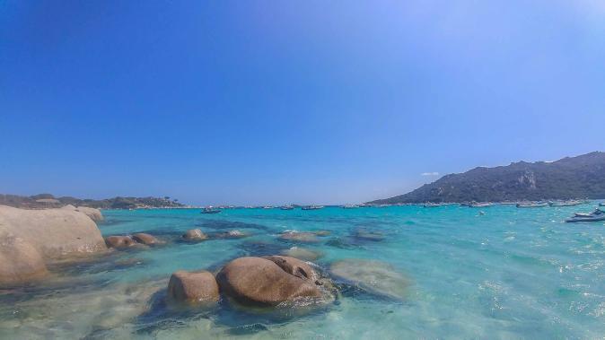 türkis Wasser mit Steinen im Wasser am Strand von Santa Giulia auf Korsika
