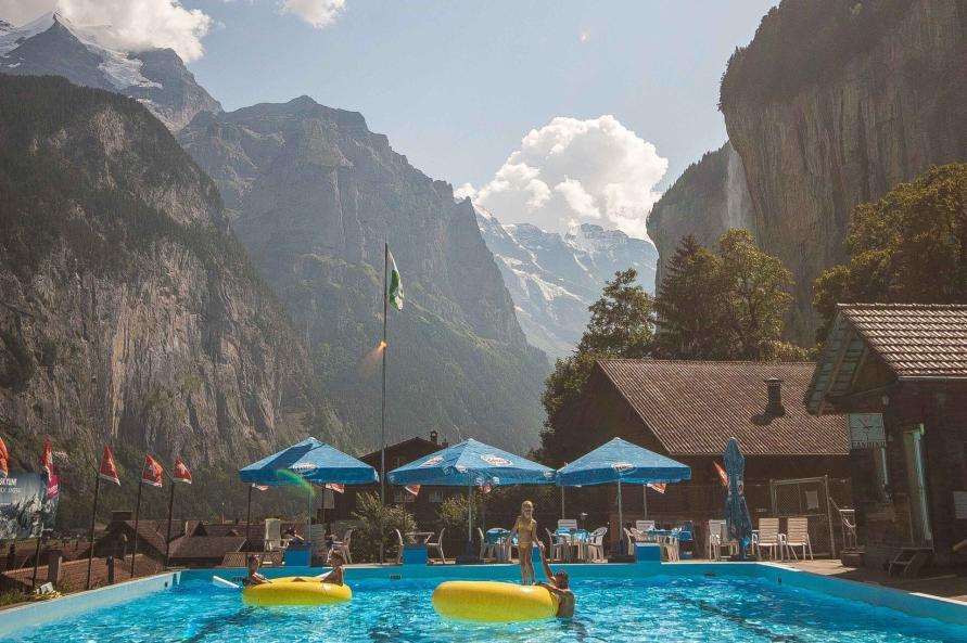 Schwimmbad in Lauterbrunnen mit zwei gelben großen Schwimmreifen und Blick ins Talende