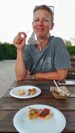 Frau sitzt beim Verköstigen von Antipasti bei iContadini